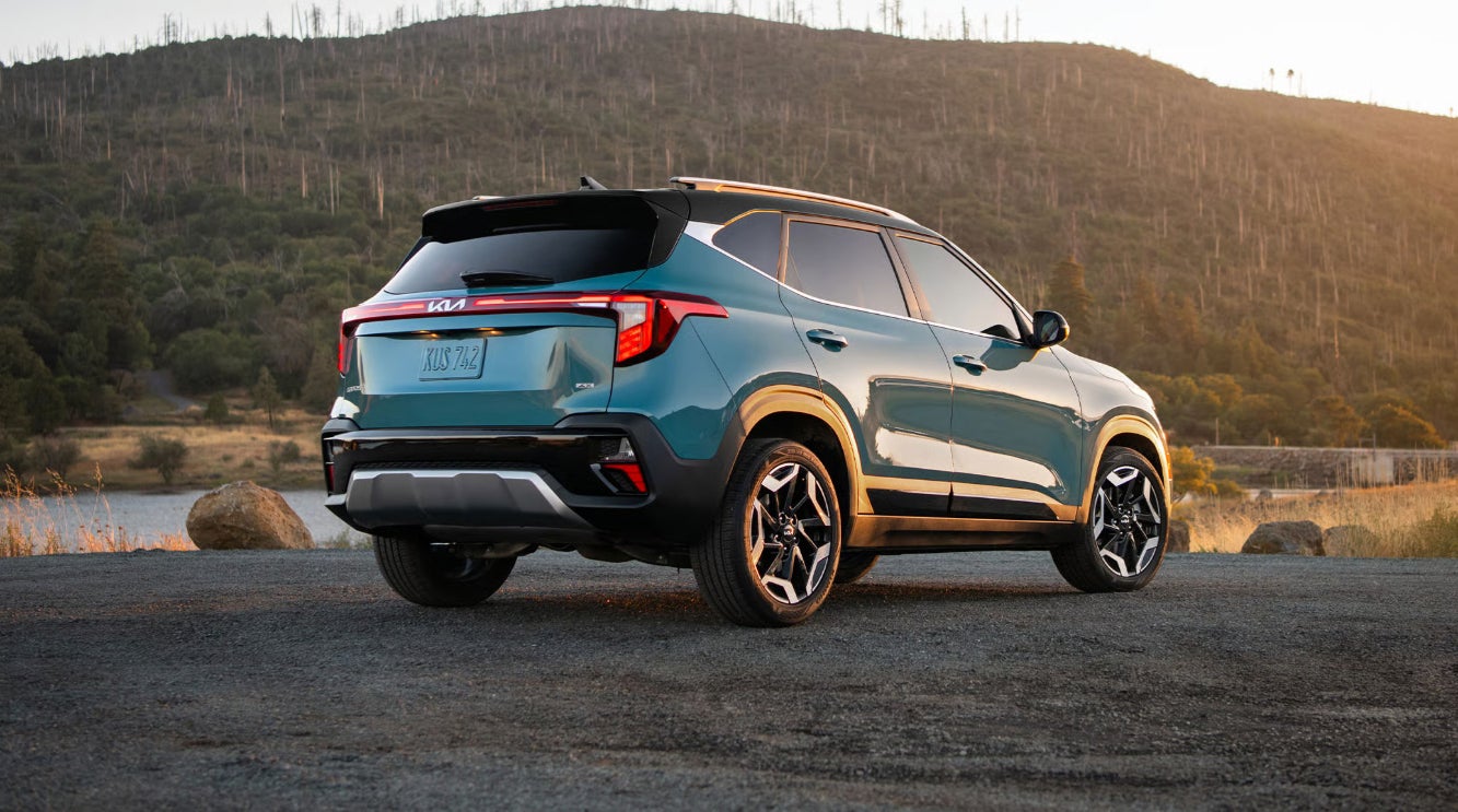 A turquoise 2026 Kia SUV parked beside a river
