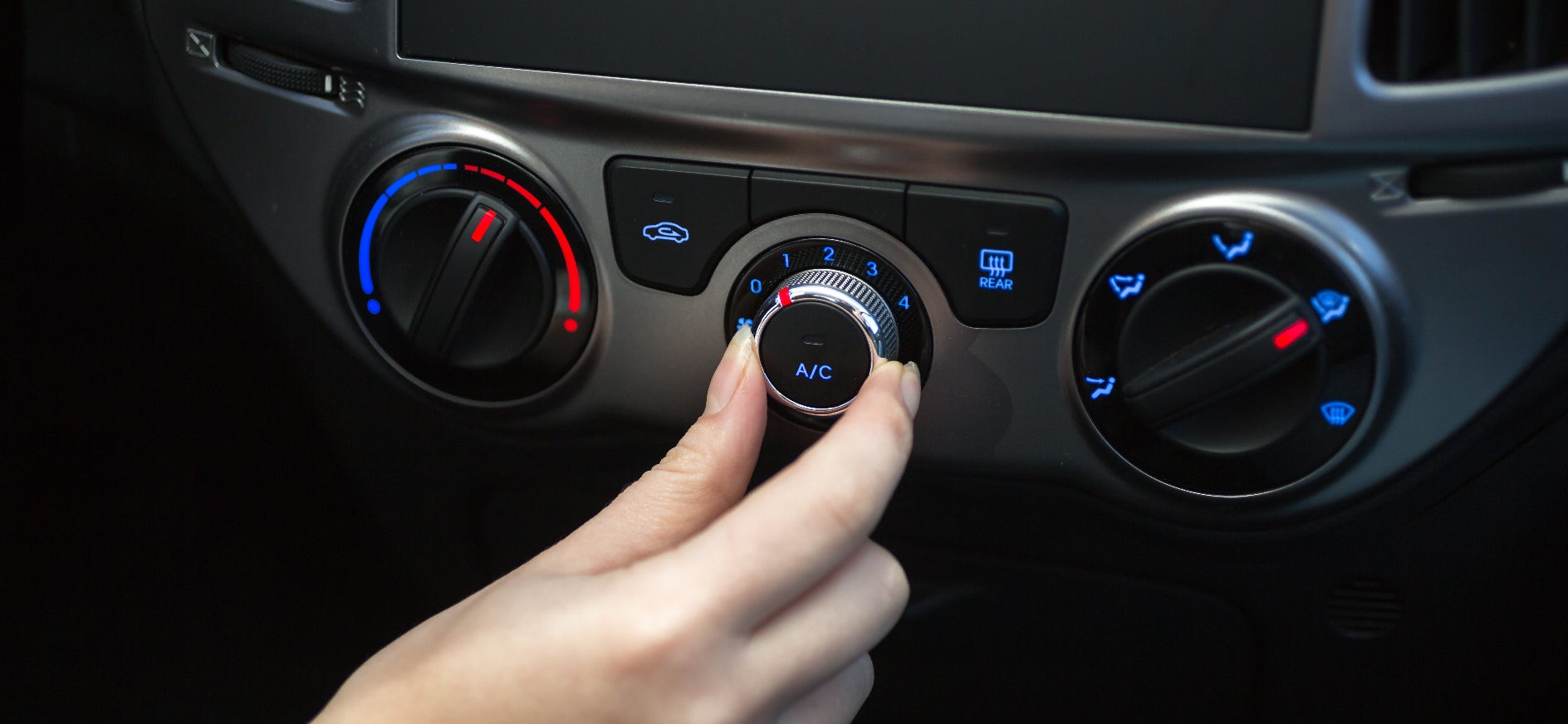 Turning air conditioner dial on a car dashboard