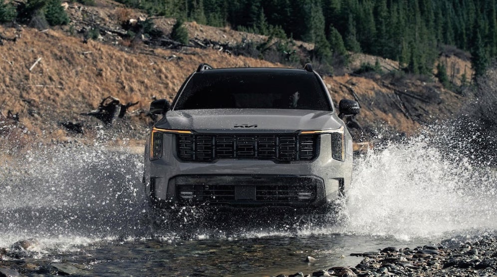 A gray 2026 Kia Sorento SUV splashing through a river